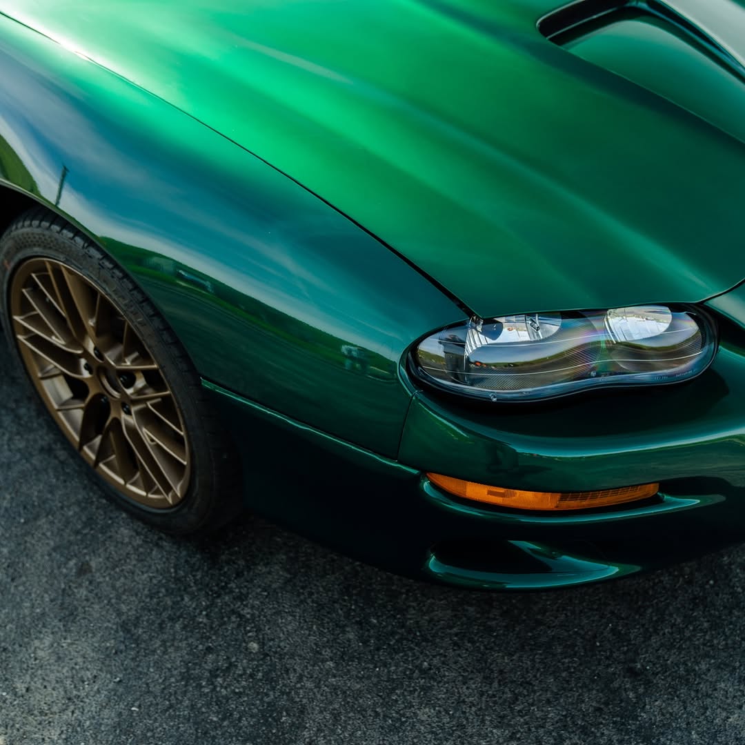 Chevrolet Camaro wrapped in Glossy Metallic La Salle Green vinyl wrap side view.