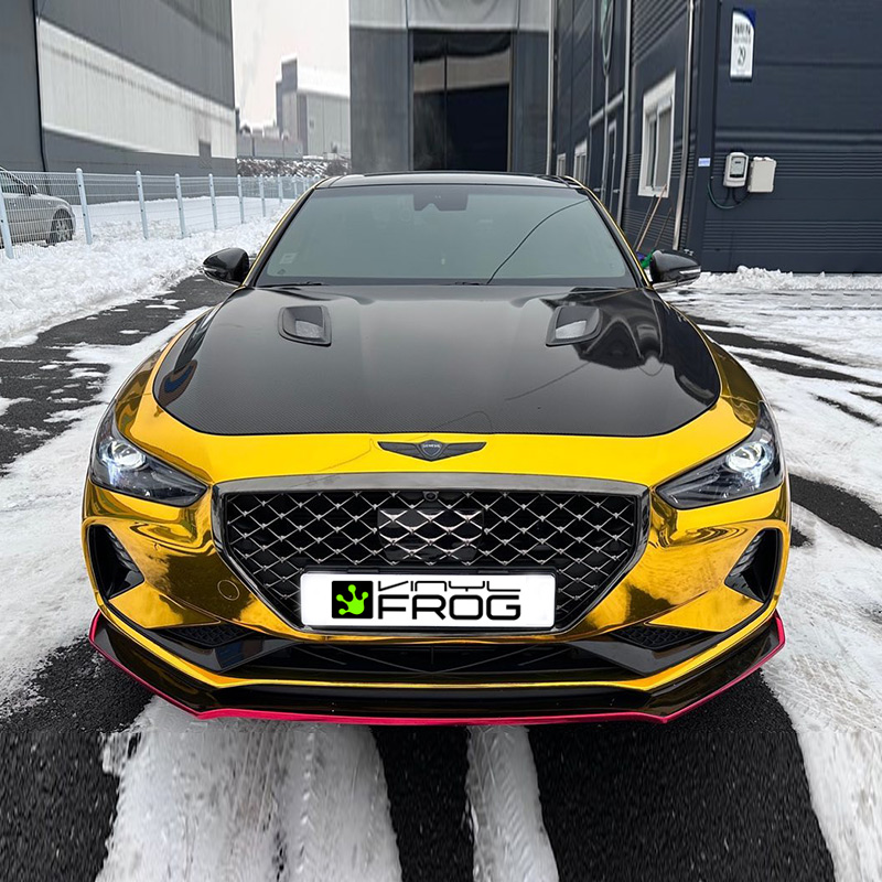 Genesis G70 wrapped in Mirror Chrome Gold vinyl wrap on road.