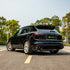 Porsche Cayenne wrapped in High Glossy Paint Black vinyl wrap on road.