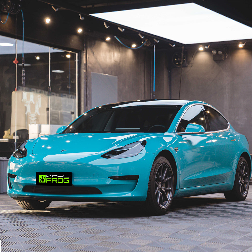 Tesla Model 3 wrapped in High Glossy Miami Blue vinyl wrap.