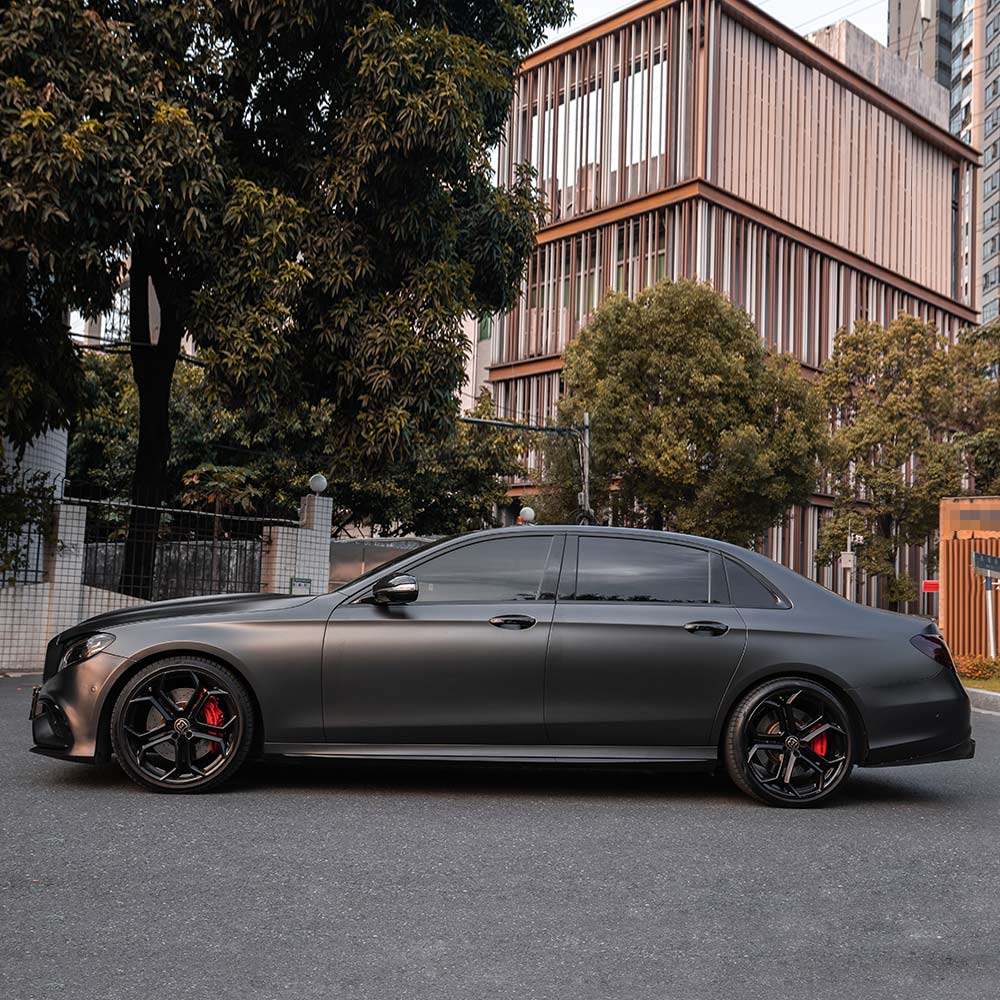Mercedes-Benz E-Class wrapped in Matte AMG Gray Vinyl Wrap on road.